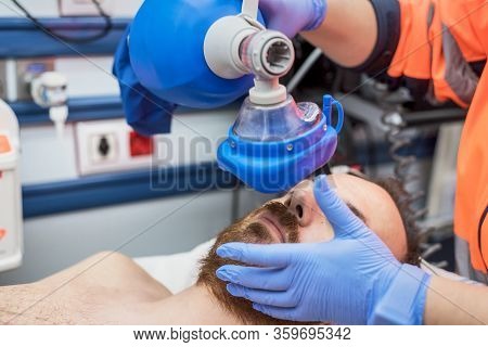 Covid-19 Respiratory Insufficiency. Urgency Doctor Using Mask Ambu Bag On A Patient With Pneumonia D