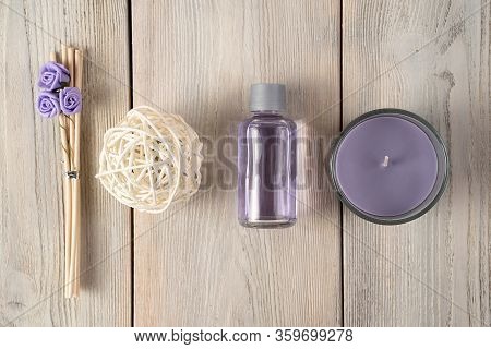 Spa Composition Of A Bottle Of Oil, Candles, Wooden Incense Sticks With Roses And A Purple Napkin On