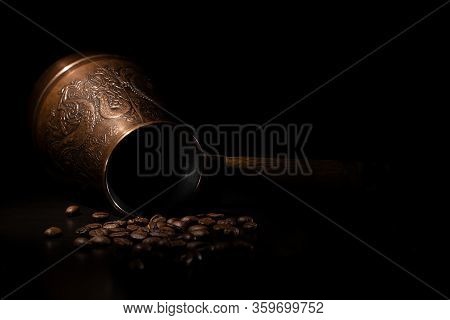 An Inverted Eastern Turk With An Engraving Of A Dragon On A Black Background, Next To Coffee Beans.