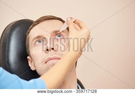 Doctor Hold Eye Drops Near Patient Face. Applying Recovery Treatment. Liquid Medicine Eyedrop Using.