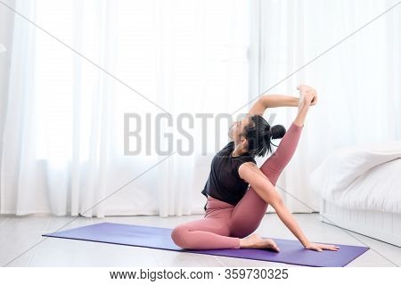Young Woman Do Yoga In A Bed Room
