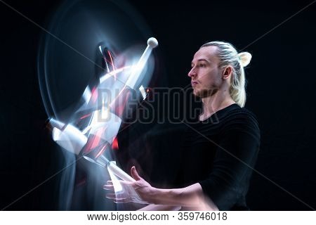 Juggler Throws Clabs In Motion With Smoothed Track. Isolated On Black