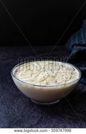 Profiteroles With White Chocolate In Glass Bowl.