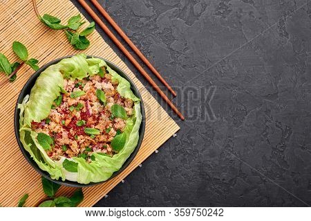 Laab Gai - Thai Minced Chicken Salad In Black Bowl At Dark Slate Background. Larb Is Thailand Cuisin