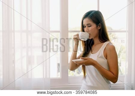 Young Asian Woman Drinking Coffee. She Stay Isolation At Home For Self Quarantine. Corona Virus Outb