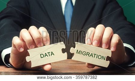Businessman Collects Wooden Puzzles With The Words Data Migration. Process Of Preparing, Selecting, 