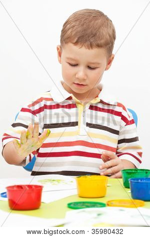 Little boy pitture vernici seduto al tavolo