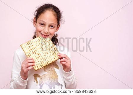 Portrait Of The Cute Teenager Girl Holding Matzah. Jewish Child Eating Matzo Unleavened Bread In Jew