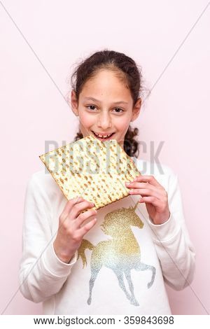 Portrait Of The Cute Teenager Girl Holding Matzah. Jewish Child Eating Matzo Unleavened Bread In Jew