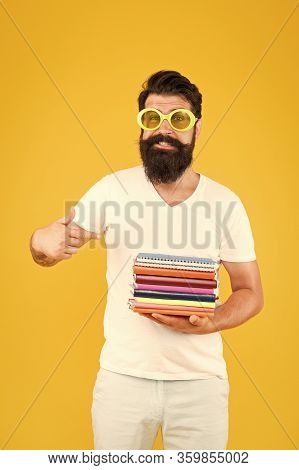 New Releases. Happy Student Pointing Finger At Books Pile. Bearded Man Pointing Index Finger Yellow 