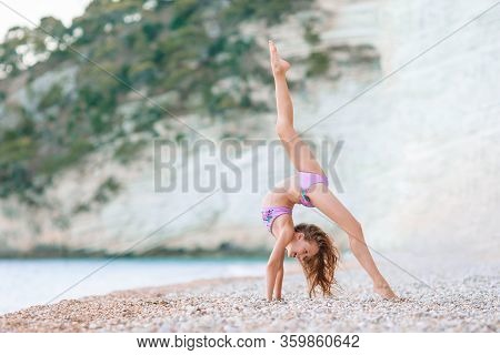Adorable Active Little Girl At Beach During Summer Vacation