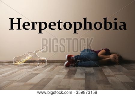Scared Little Girl Suffering From Herpetophobia On Floor Indoors. Fear Or Aversion To Reptiles