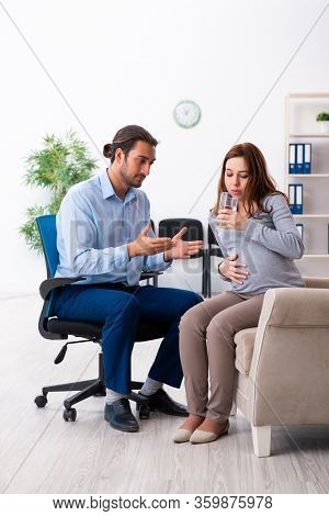 Pregnant woman visiting young male psychologist