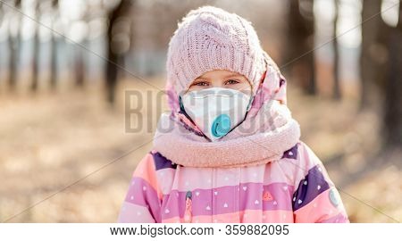 Prety little girl in medical mask on nature background