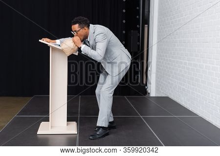 Stressed African American Businessman Breathing With Paper Bag And Having Panic Attack During Busine