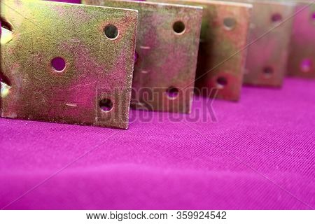 Arrow Made Of Brackets Isolated On Pink. Metal Corners Are Directed To The Left With A Place For The