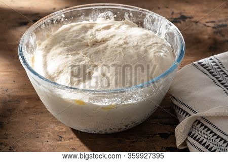 Bowl Of Fresh Raw Dough On Wooden Background