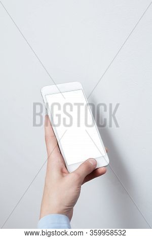 Closeup Shot Of A Woman Hold On Mobile Phone. Girl's Hand Holding A Modern Smartphone. Blank Screen 
