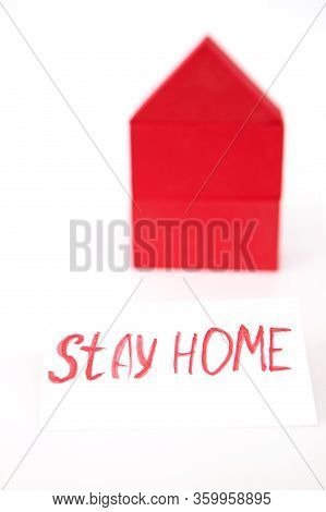 Toy House On A White Background. A Toy House Made Of Red Cubes. With A Red Sign Saying Stay At Home.