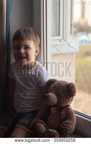 Stay At Home Quarantine Coronavirus Prevention Of The Pandemic. A Child And His Teddy Bear On The Wi