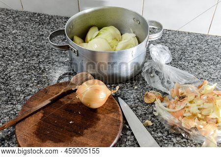 Preparing Items For Cooking An Onion Tart As A Wooden Spoon, A Knife And An Onion.