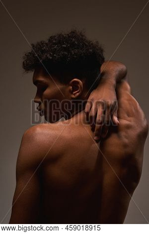 Partial Back View Of Black Handsome Guy Posing With Closed Eyes. Young Brunette Curly Man With Naked