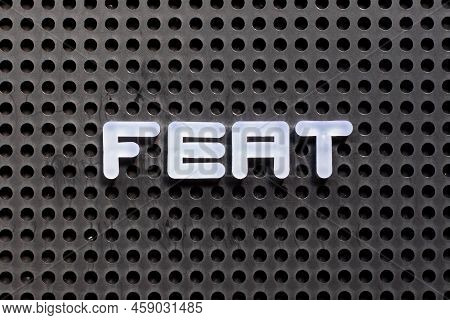 White Color Letter In Word Feat On Black Pegboard Background