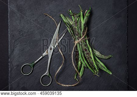 String Beans On A Black Background. A Bunch Of Raw Green Beans Tied With A Rope. Healthy Vegetable