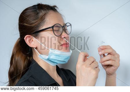 Young Asian Woman Using Rapid Antigen Test Kit By Nasal Swab Herself For Takes A Sample Of Cells Fro