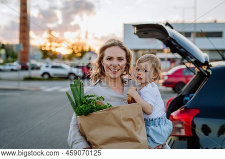 Young Mother With Little Daughter After Shopping Holding Zero Waste Shopping Bags With Grocery Near 