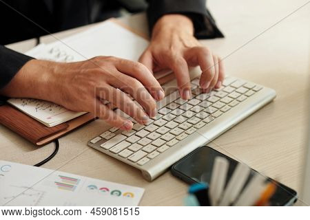 Close-up Image Of Entrepeneur Typing On Keyboard At His Officce Desk When Answering E-mail From Coll