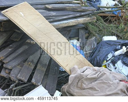 Garbage From Human Activity Lies In A Rural Garbage Dump: Boards, Furniture, Branches, Bags