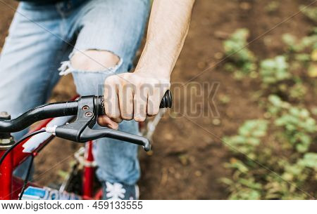Side View Of Hands On Bicycle Handlebars With Copy Space. Concept Of Cyclist Hands On The Handlebars