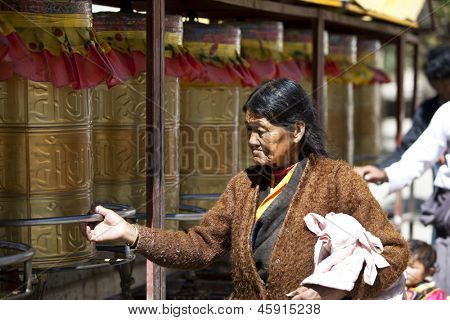LHASA, TIBET-octubre 07: Tibetana una mujer peregrino budista es girar las ruedas de oración para wis buena