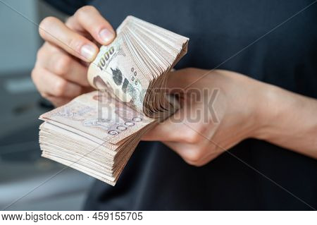 Close Up Of Someone Hands Counting A Pile Of One Thousand Thai Baht. Baht Is Money Currency Of Thail
