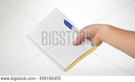 A Mans Right Hand Holds A Pen And Notebook Space For Inscription. High Quality Photo
