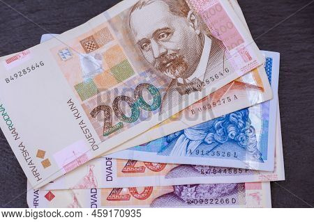 Kuna Croatian Money In Various Copies On Stone. The Currency Of Croatia.
