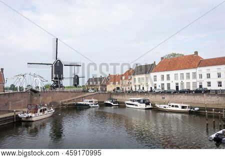 Heusden, Brabant, The Netherlands - May 7, 2022: Drawbridge And Windmill At The Harbor With Boats In