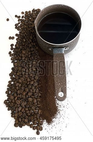 Coffee Beans, Ground Coffee And Coffee Cezve. The Photo Shows Coffee Beans And Ground Coffee. Nearby