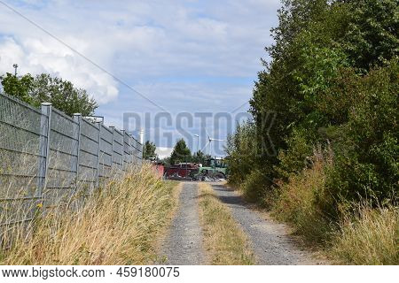 Kaisersesch, Germany - 07 26 2022: Narrow Dirt Road With A Tractor Depot At The End