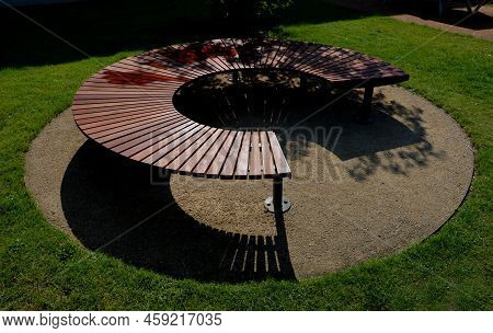 Circular Bench Made Of Brown-red Teak Wood. Tropical Impregnated Podia Boards For Sunbathing Visitor