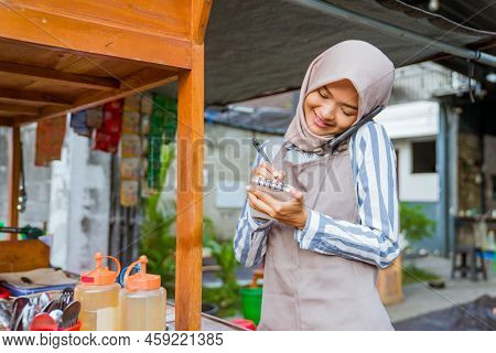 Muslim Seller Taking Order From Customer Through Phone