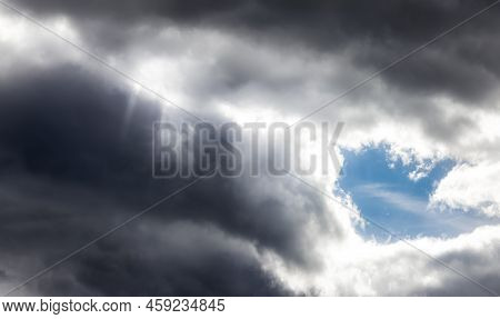 Dramati Dark Clouds In The Sky With Sunrays. Cloudscape Background