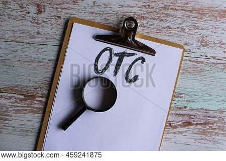 Top View Image Of Paper Clipboard With Text Otc Or Over The Counter And Magnifying Glass