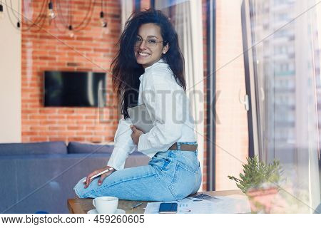Young Beautiful Smiling Woman At Eyeglasses With Tablet Pc And Business Documens Sitting On Table At