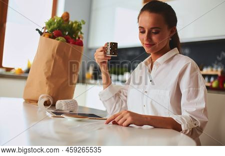 Young Woman Planning Expenses And Paying Bills On Her Kitchen