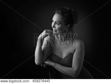Portrait Of A Sensual Fifty Year Old Woman On Grey Studio Background. Monochrome Shot.