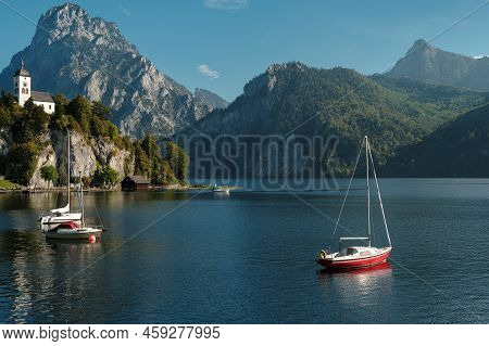 Scenic View On The Perched Johannesberg Chapel In Austria, Surrounded By Mountains And The Lake Trau