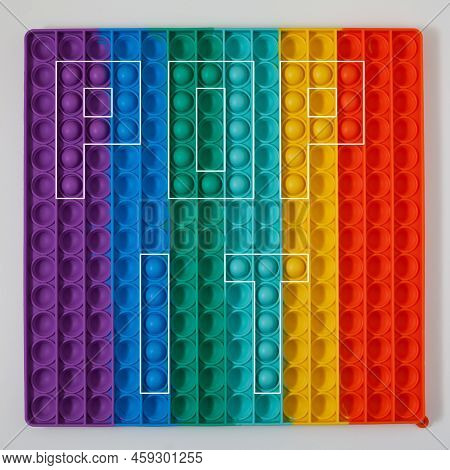 Inscription Pop It  On Colorful Background. Pop It Is A Popular Silicone Toys For Children. Letter S