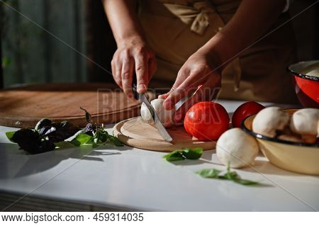 Details: Chefs Hands Using A Kitchen Knife, Slicing Fresh Mushroom Champignon On A Chopping Board. F